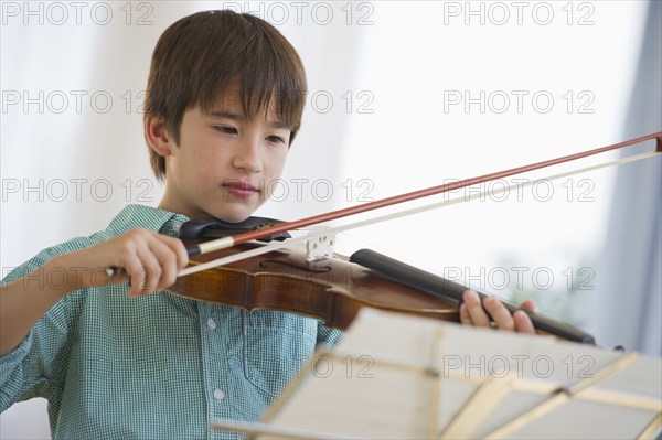 Mixed race boy playing violin