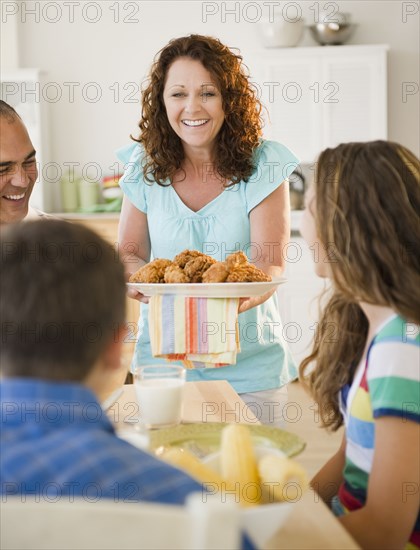 Smiling woman serving family dinner