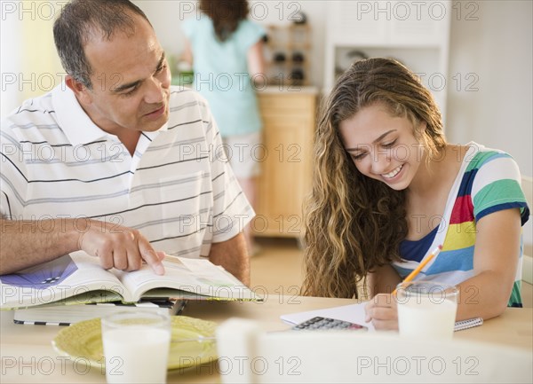 Hispanic father helping daughter with homework