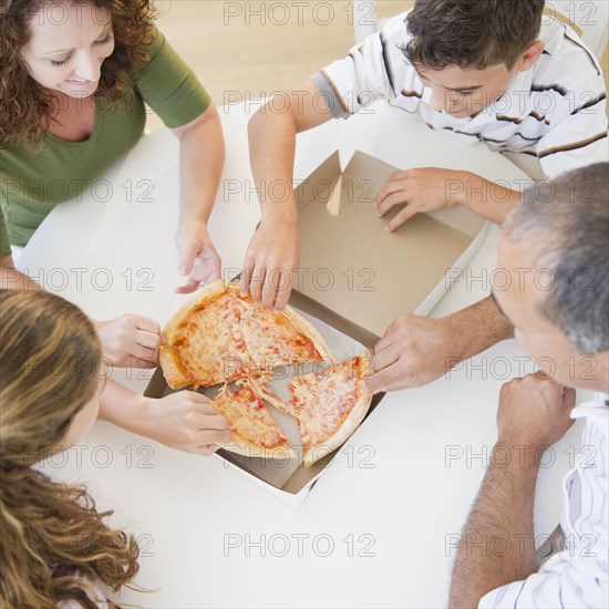 Hispanic family eating pizza together