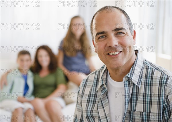 Smiling Hispanic man with family in background