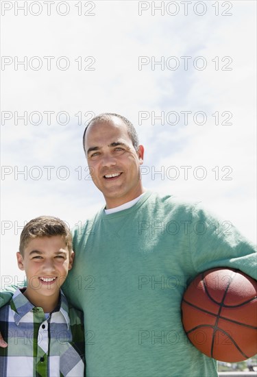 Hispanic father and son with basketball