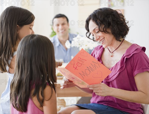 Daughters giving mother Mother's Day card