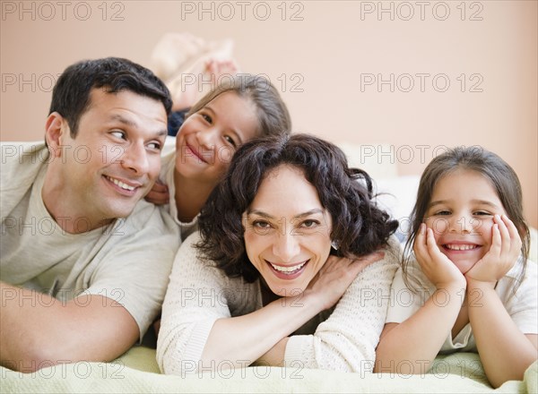 Happy family laying on bed together