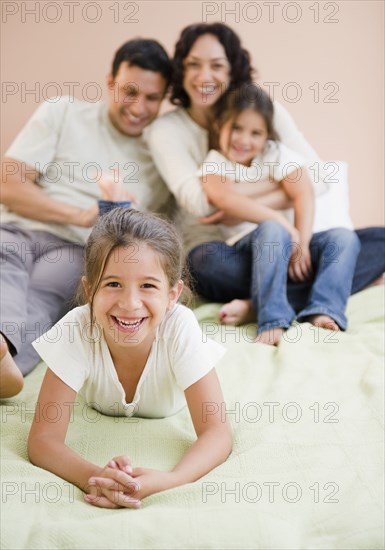 Happy family laying on bed together
