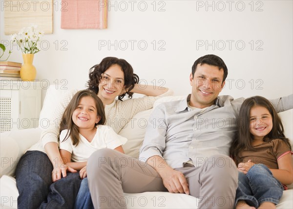 Happy family sitting on sofa together