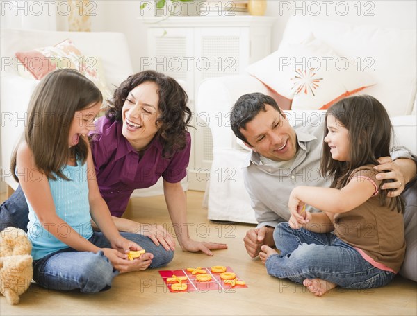 Father and mother playing game in livingroom with children