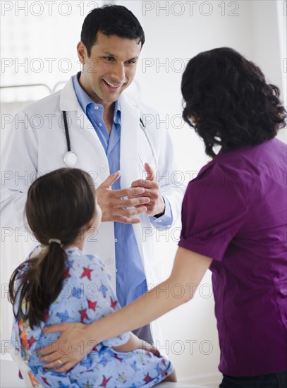 Doctor talking to mother and daughter in examination room