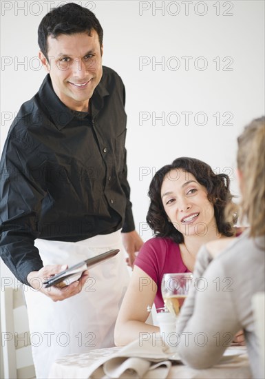 Waiter bring check to customers at table in restaurant