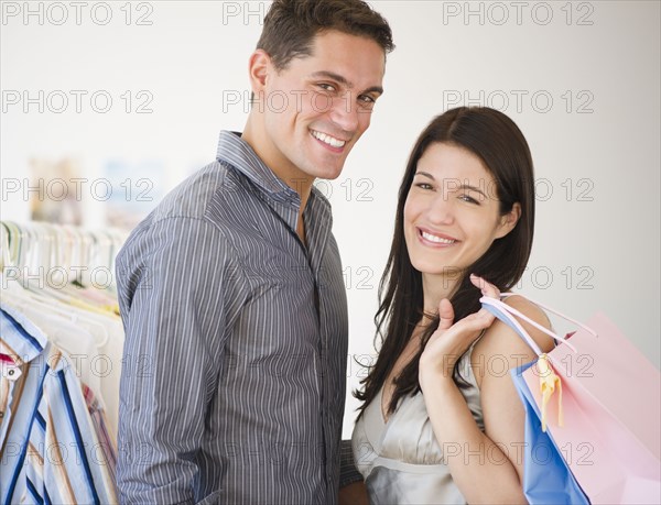 Smiling couple shopping for clothing together