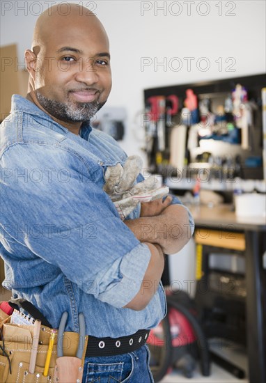 Construction worker in workshop with arms crossed