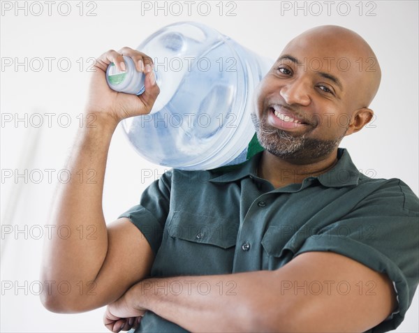 African American deliveryman holding water bottle