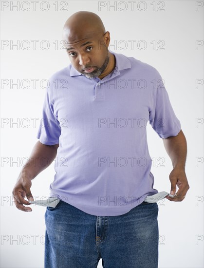 Sad African American holding out empty pockets