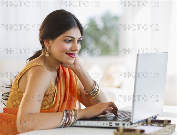 Indian woman in traditional Indian clothing using laptop