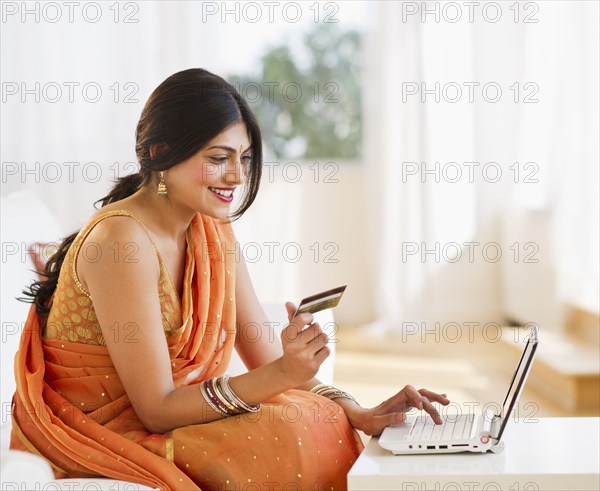 Indian woman in traditional Indian clothing using credit card online