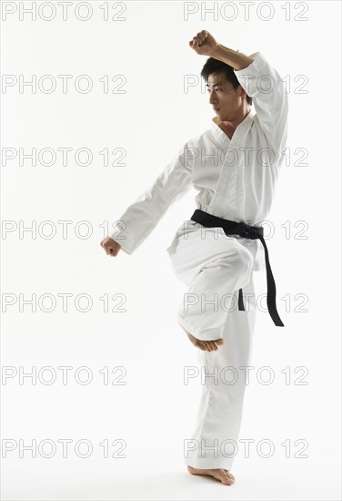 Asian male black belt practicing karate