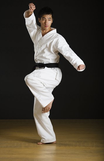 Asian male black belt practicing karate