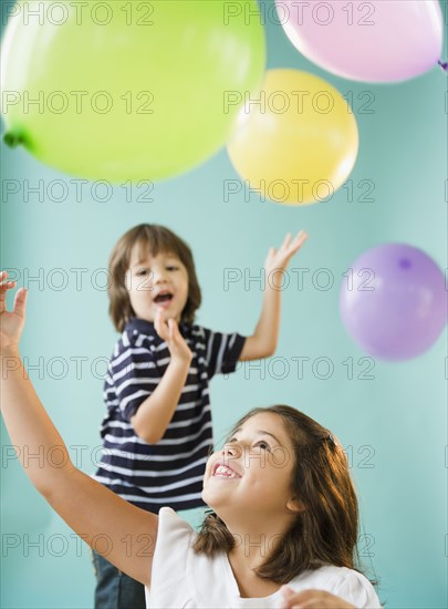 Hispanic brothers and sisters playing with balloons