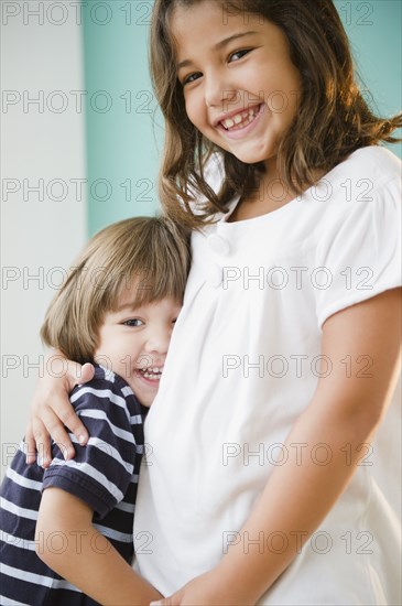 Hispanic girl hugging her brother