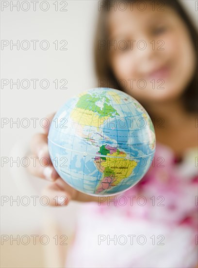 Hispanic girl holding small globe