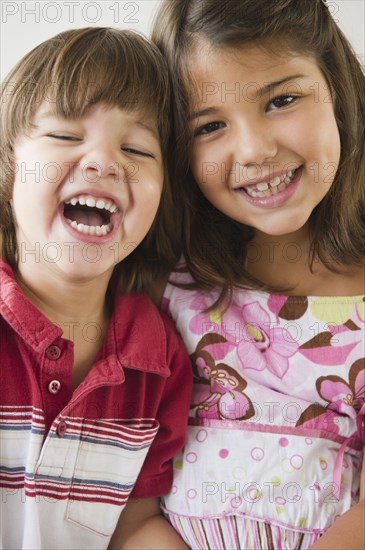 Hispanic brother and sister smiling