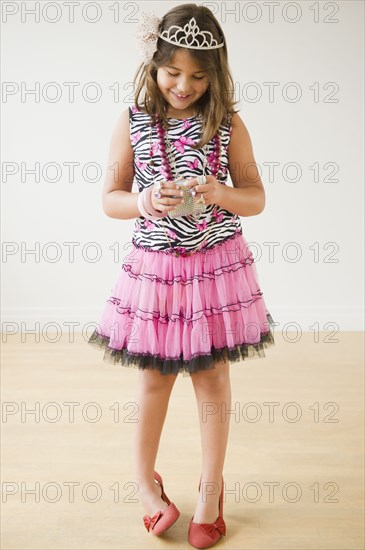 Hispanic girl dressing up and wearing tiara