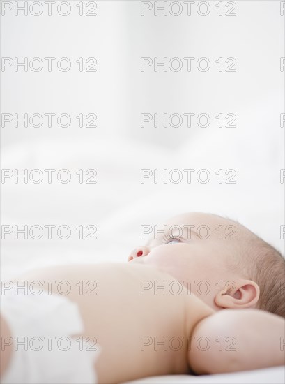 Mixed race baby laying on bed