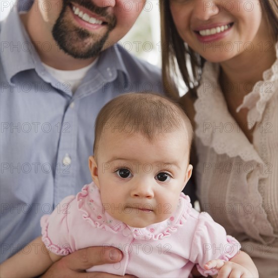 Mother and father holding baby daughter