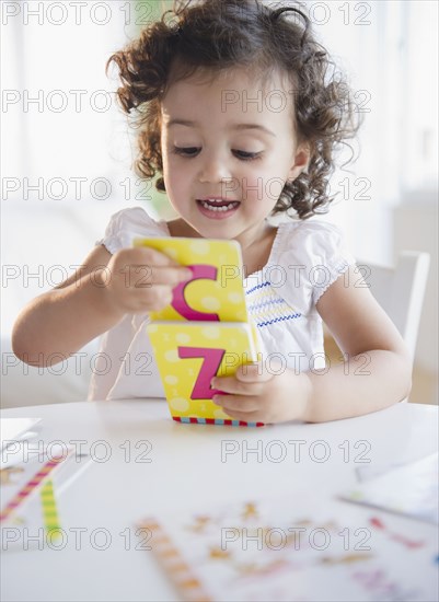 Mixed race girl playing with alphabet cards