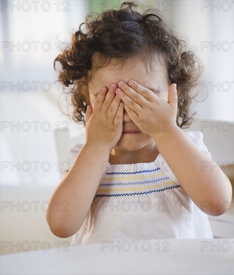 Mixed race girl covering her eyes