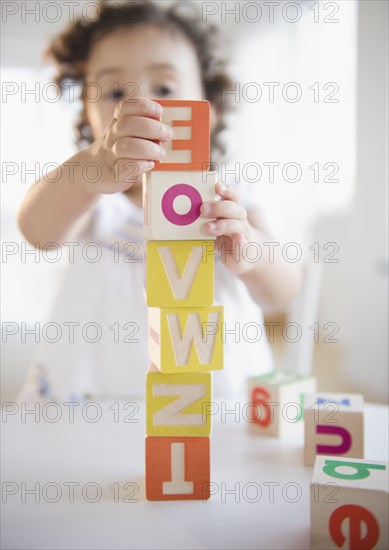 Mixed race girl stacking blocks