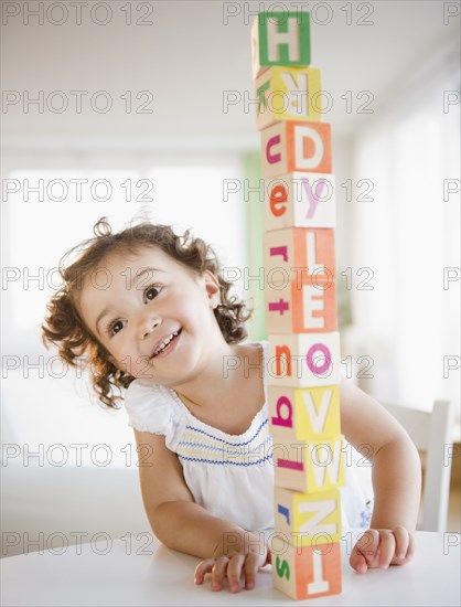 Mixed race girl stacking blocks
