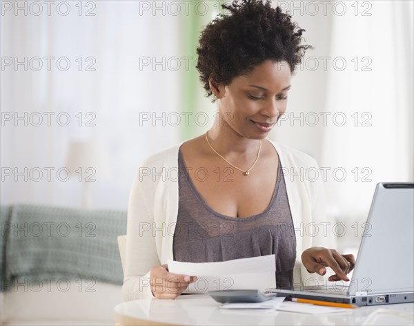 Black woman paying bills on computer