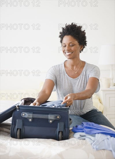 Black woman packing suitcase