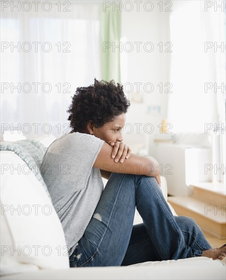 Serious Black woman sitting on sofa