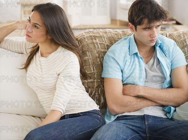 Angry couple sitting on sofa together