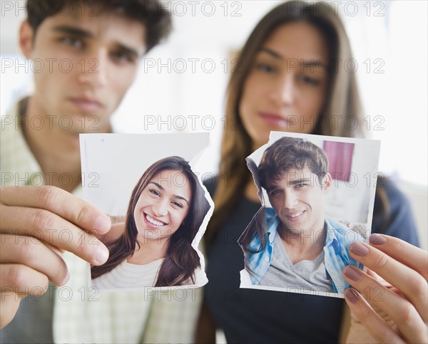 Couple holding torn photograph