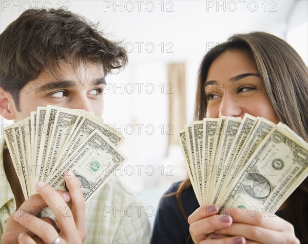 Couple holding handfuls of money