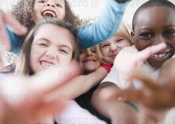 Grinning children reaching toward camera