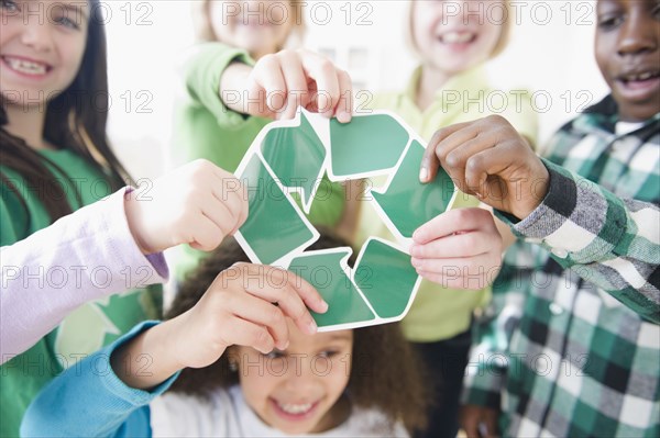 Children holding green recycling symbol