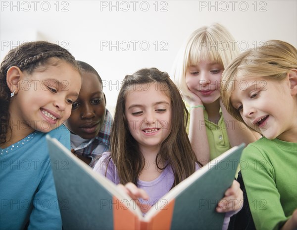 Children reading book together