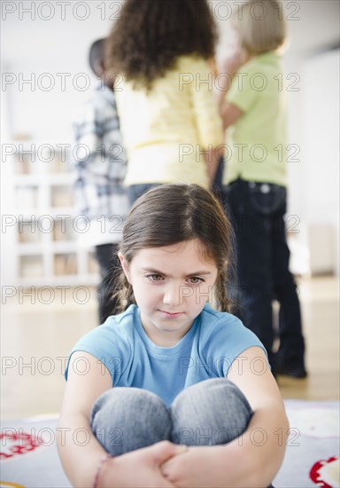 Lonely girl ignoring friends playing