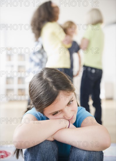 Lonely girl ignoring friends playing