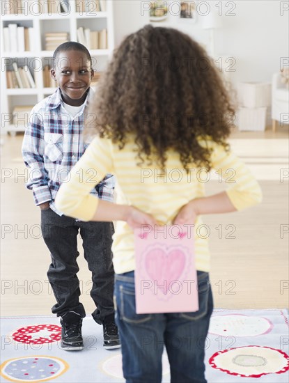 Girl holding Valentine card behind her back