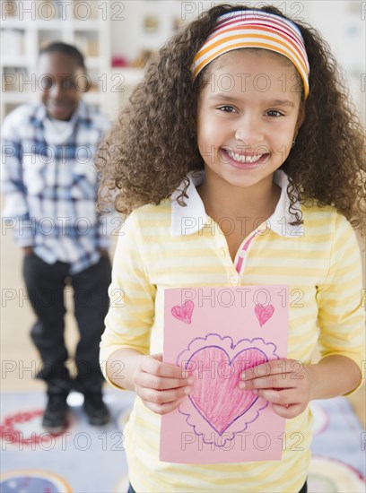 Smiling girl holding Valentine card