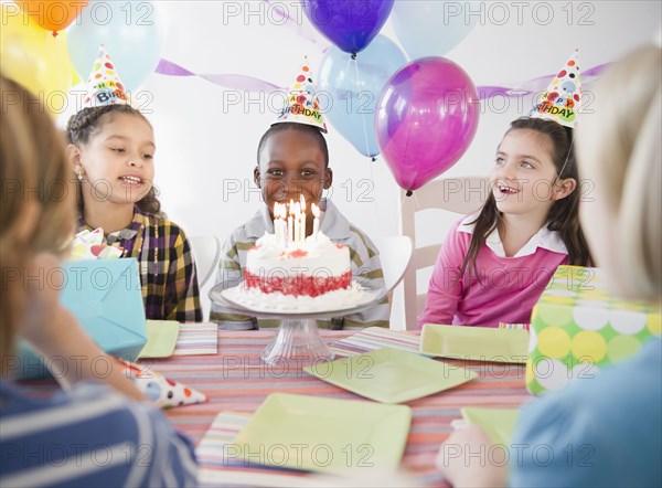 Happy boy at birthday party with birthday cake