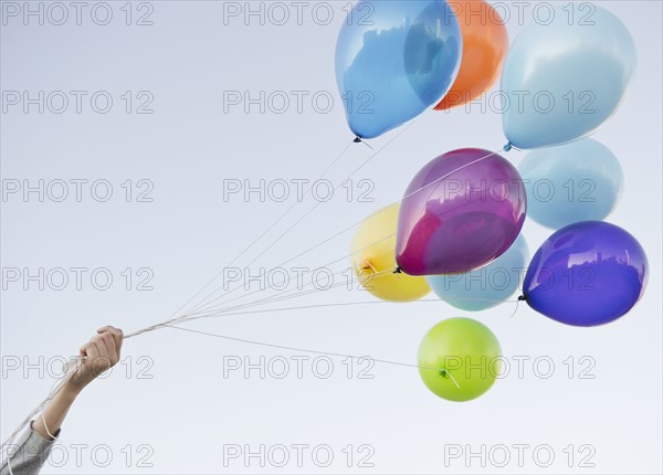 Caucasian woman holding bunch of balloons