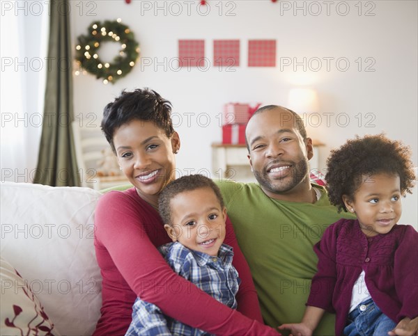 Black family relaxing on sofa together