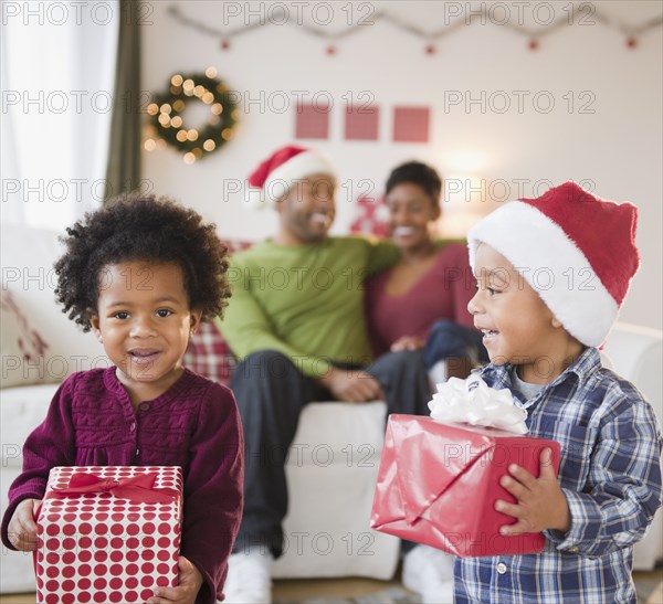 Black brother and sister holding Christmas gifts