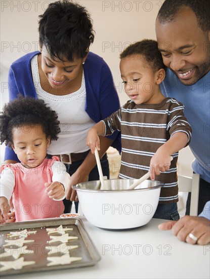 Black family baking cookies together